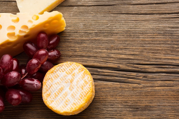 Vista superior de queso gourmet y uvas con espacio de copia