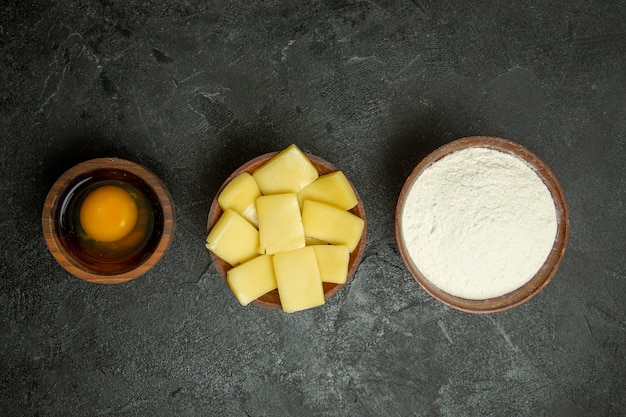 Vista superior de queso en rodajas con harina sobre fondo gris harina de masa hornear alimentos crudos