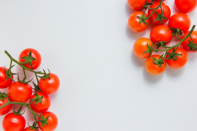 Vista superior racimos de tomates sobre fondo blanco. espacio horizontal para texto