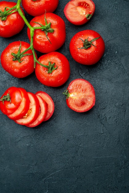 Foto gratuita vista superior de la rama de tomate fresco tomates picados en mesa negra con lugar de copia