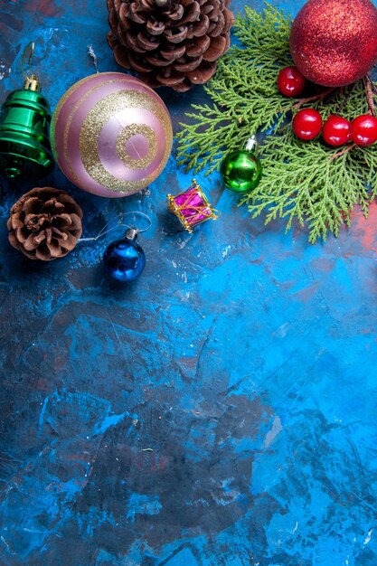 Vista superior ramas de abeto ramas de abeto conos juguetes de árbol de Navidad sobre fondo azul