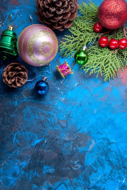Vista superior ramas de abeto ramas de abeto conos juguetes de árbol de Navidad sobre fondo azul