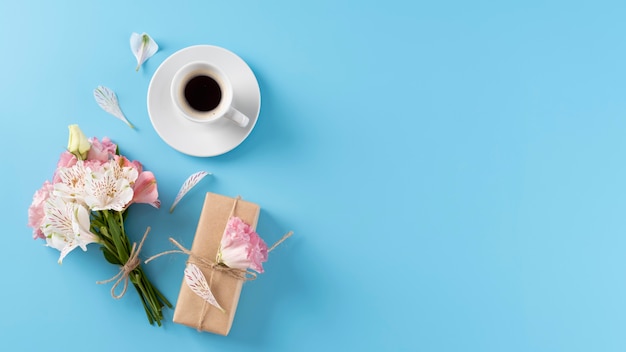 Vista superior del ramo de flores con caja de regalo y taza de café