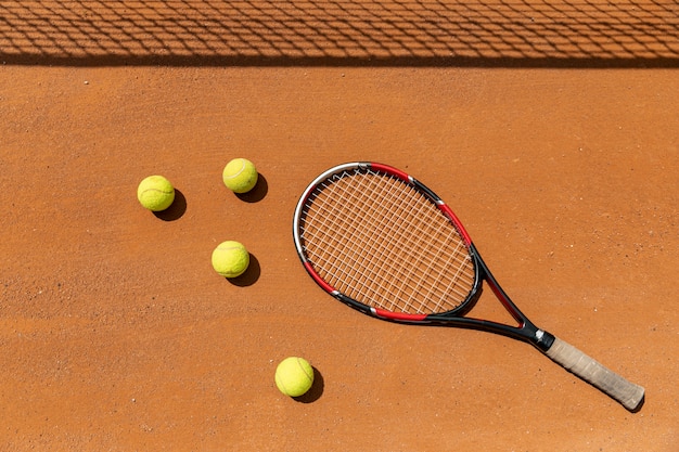 Vista superior de raquetas y pelotas de tenis en la cancha