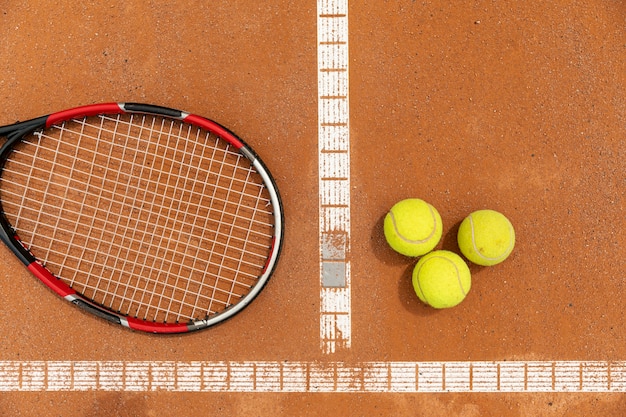 Vista superior de raquetas y pelotas de tenis en la cancha