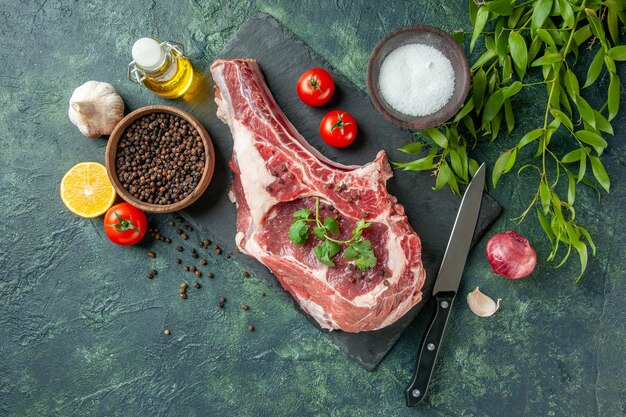 Vista superior de la rebanada de carne fresca con tomates y pimiento sobre fondo azul oscuro carnicero de color de comida de pollo de vaca animal de cocina