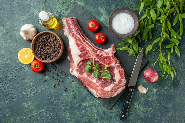 Vista superior de la rebanada de carne fresca con tomates y pimiento sobre fondo azul oscuro carnicero de color de comida de pollo de vaca animal de cocina