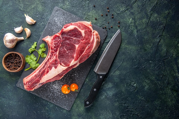 Foto gratuita vista superior rebanada de carne grande carne cruda con pimienta sobre superficie oscura