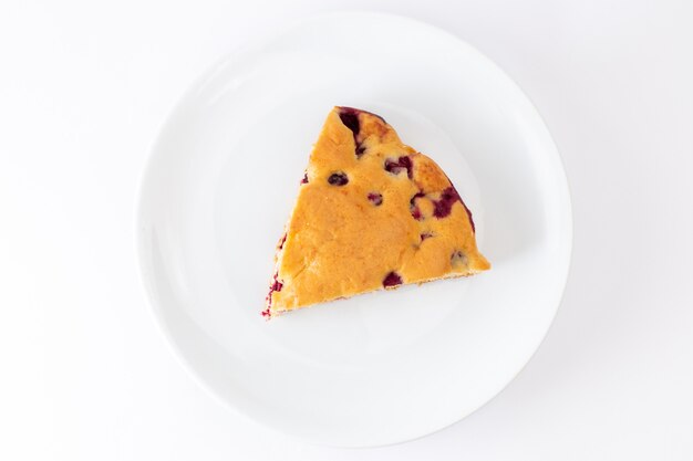 Vista superior de la rebanada de pastel de cereza dentro de la placa blanca sobre el fondo blanco hornear masa de azúcar dulce galleta pastel