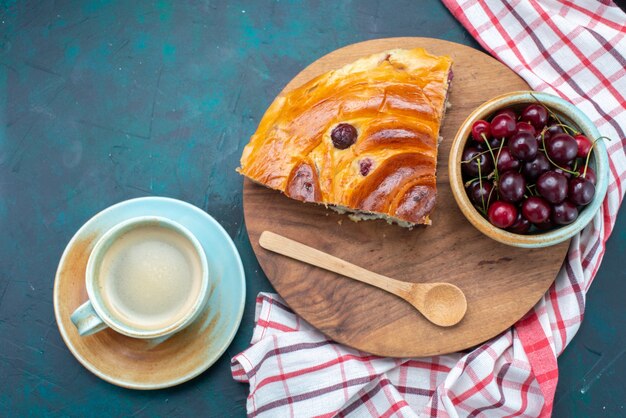 Vista superior de la rebanada de pastel de cereza con guindas frescas y leche en el escritorio oscuro, pastel de frutas hornear té dulce