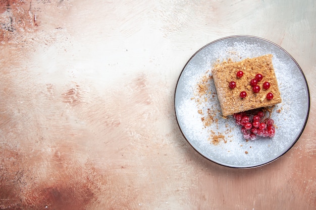 Vista superior rebanada de pastel delicioso con frutos rojos en mesa de luz pastel dulce pastel de galletas