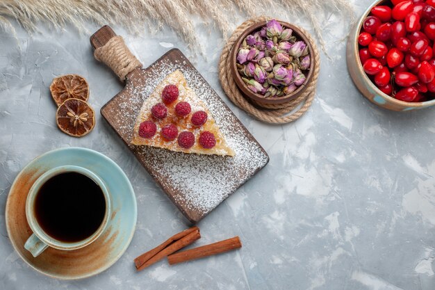 Vista superior rebanada de pastel delicioso con taza de té en el escritorio blanco pastel galleta dulce azúcar hornear