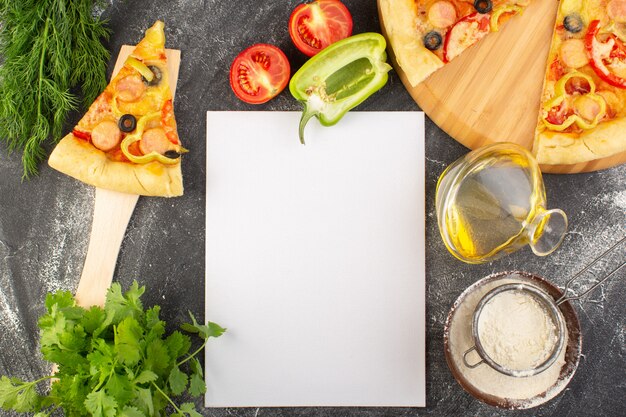 Vista superior de la rebanada de pizza con aceitunas negras, tomates y salchichas junto con aceite de verduras y verduras en el escritorio gris comida pizza de masa italiana