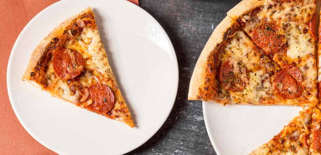 Vista superior rebanada de pizza de pepperoni en placa