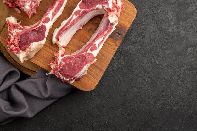 Vista superior rebanadas de carne cruda sobre fondo gris oscuro foto de carne de color vaca pollo con pimienta cruda