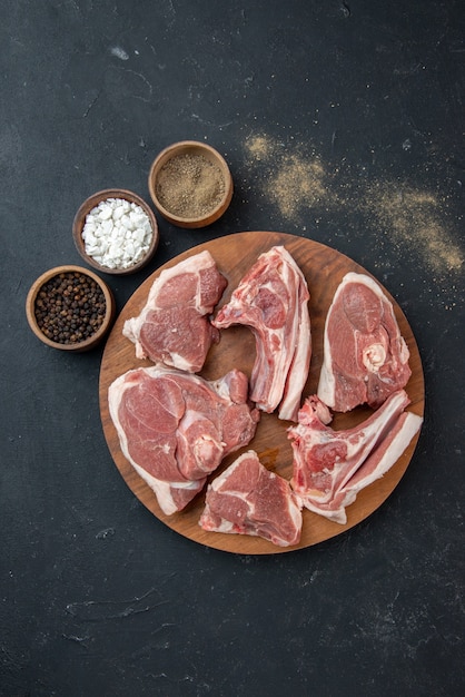 Vista superior rebanadas de carne fresca carne cruda en comida oscura comida fresca comida de vaca animal de cocina