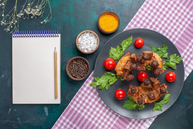 Vista superior rebanadas de carne frita con bloc de notas verdes y tomates cherry dentro de la placa en la superficie oscura comida de carne comida vegetal freír