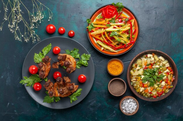 Vista superior rebanadas de carne frita con sopa de verduras y condimentos en el escritorio azul oscuro comida vegetal comida carne cena salud