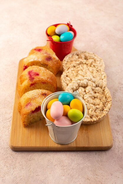 Foto gratuita una vista superior de las rebanadas de pastel de cereza con caramelos y galletas en el escritorio de color rosa brillante pastel galleta dulce azúcar