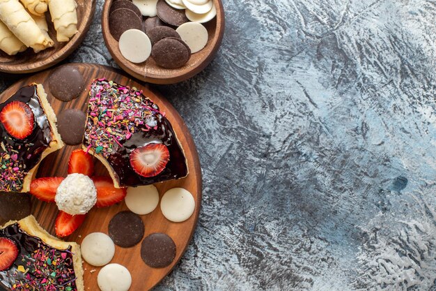 Vista superior de las rebanadas de pastel con nueces y galletas en una superficie oscura