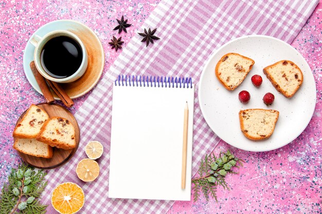 Vista superior de las rebanadas de pastel con una taza de café y un bloc de notas sobre fondo rosa pastel hornear galleta dulce pastel de color azúcar galleta