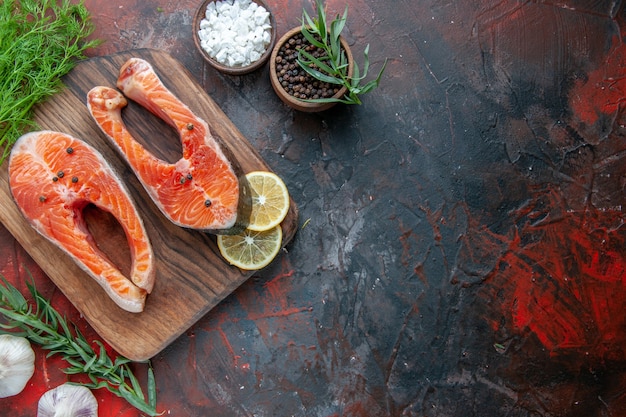 Foto gratuita vista superior rebanadas de pescado crudo sobre fondo oscuro