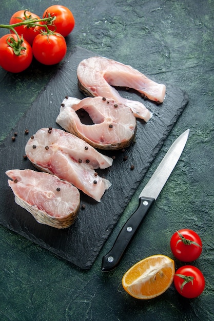 Foto gratuita vista superior rebanadas de pescado fresco con tomates rojos en la pared oscura carne de océano comida de mar comida de agua plato de pimienta