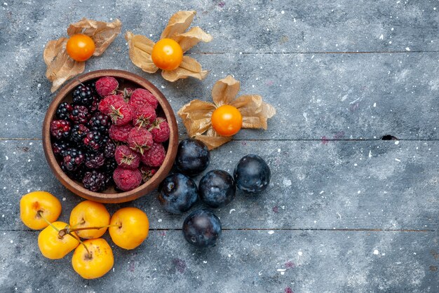 Vista superior del recipiente con bayas frescas frutas maduras en gris, bayas frescas bosque suave