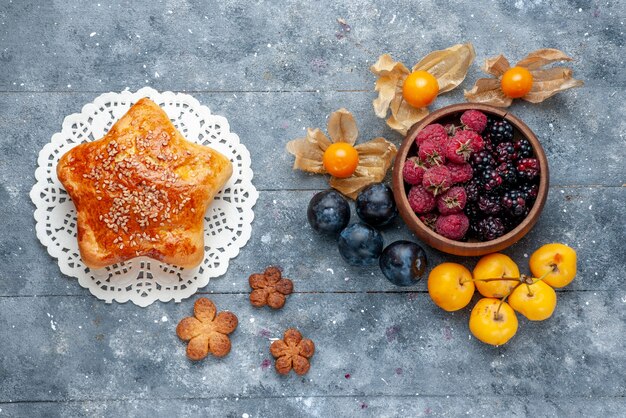 Vista superior del recipiente con bayas frescas frutas maduras con pastelería dulce en gris, bayas frescas bosque suave