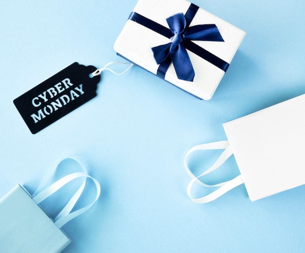 Vista superior del regalo con bolsas de compras y etiqueta para cyber monday