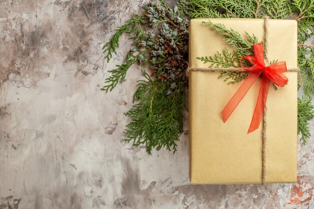 Vista superior de regalo de Navidad con rama verde en blanco regalo de vacaciones color año nuevo Navidad