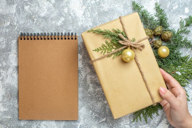 Vista superior de regalo de Navidad con rama verde y bloc de notas en blanco Navidad color regalo foto de vacaciones año nuevo
