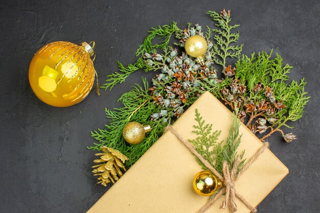 Vista superior regalo de navidad ramas de abeto juguetes de árbol de navidad en superficie beige