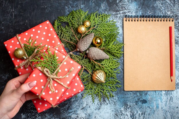 Vista superior de regalos de Navidad y cuaderno vacío con lápiz rojo