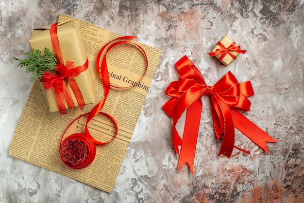 Vista superior de regalos de Navidad con lazos rojos sobre fondo blanco.