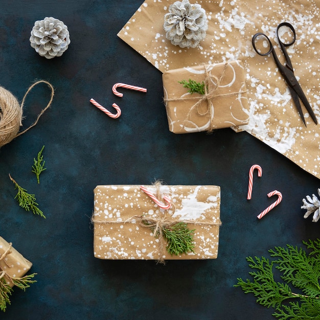 Vista superior de regalos de navidad con piñas y bastones de caramelo