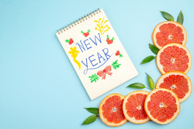 Foto gratuita vista superior de rodajas de fruta de pomelos frescos sobre el fondo azul.