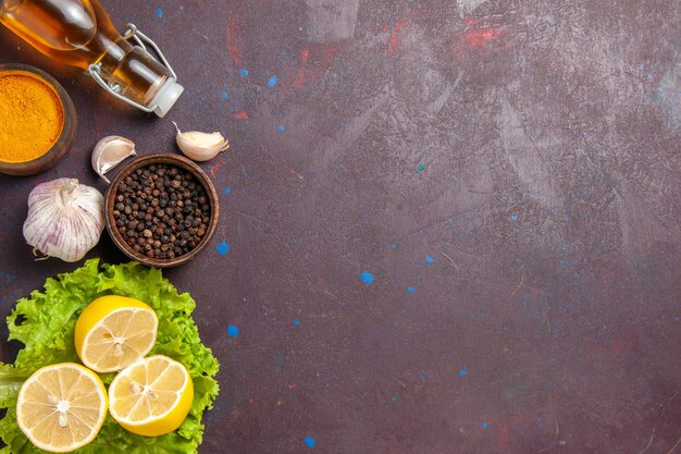 Foto gratuita vista superior de rodajas de limón fresco con ajo y condimentos en la oscuridad