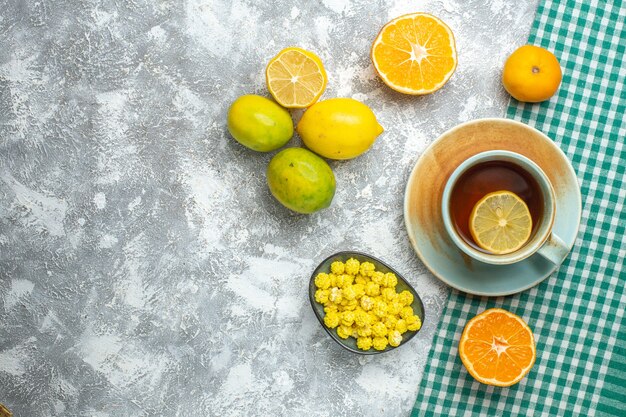 Vista superior de rodajas de limón fresco con una taza de té en la mesa de luz