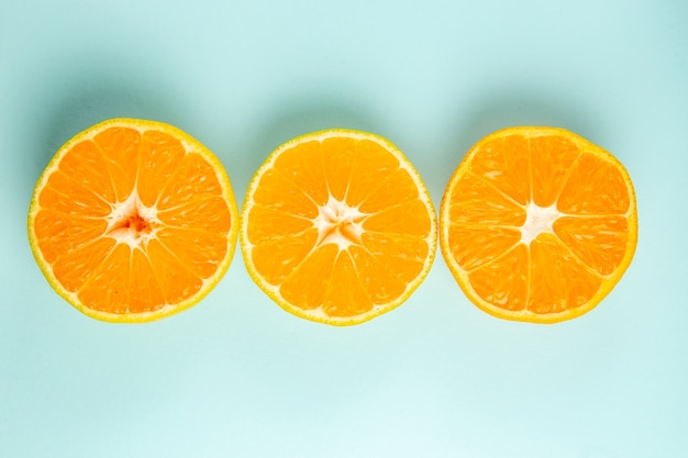 Foto gratuita vista superior de rodajas de mandarina fresca forradas sobre el fondo azul claro