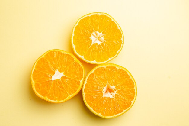 Vista superior de rodajas de mandarina fresca sobre fondo blanco.