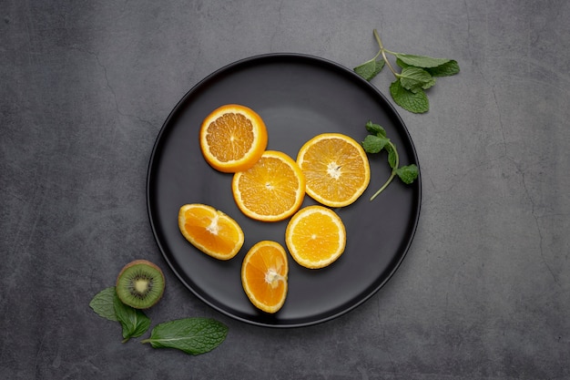 Foto gratuita vista superior de rodajas de mandarina en un plato con menta y kiwi