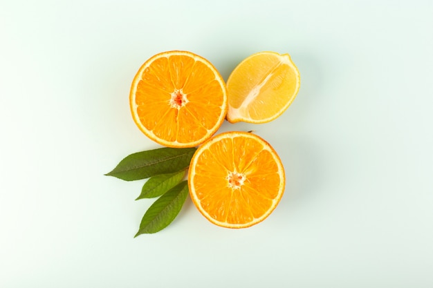 Una vista superior en rodajas de naranja fresca madura jugosa melosa aislada piezas de medio corte con hojas verdes sobre el fondo blanco color de fruta cítrica