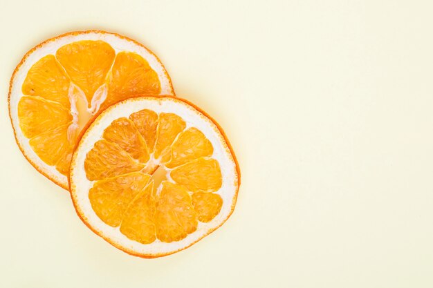 Vista superior de rodajas de naranja secas aisladas sobre fondo blanco con espacio de copia