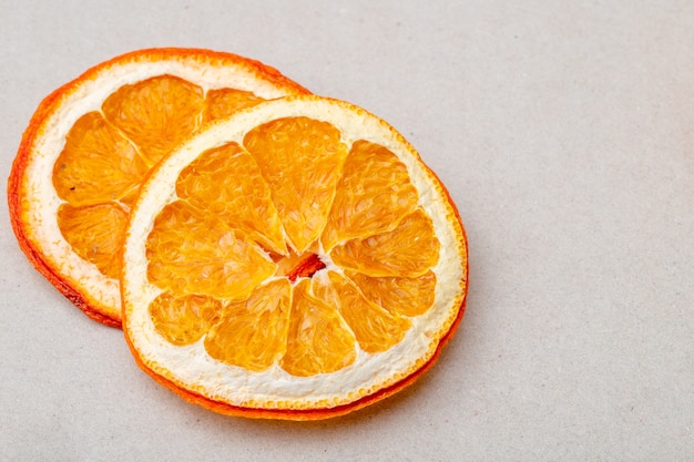 Vista superior de rodajas de naranja secas dispuestas sobre fondo blanco con espacio de copia