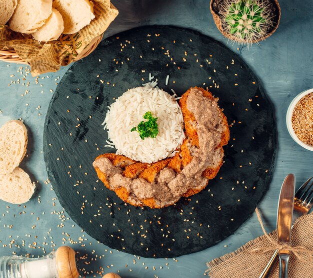 Vista superior de rodajas de nugget de pollo con arroz sobre tabla de piedra