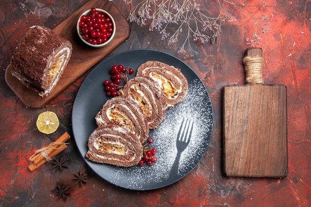 Vista superior de rollos de galletas con frutos rojos sobre superficie oscura