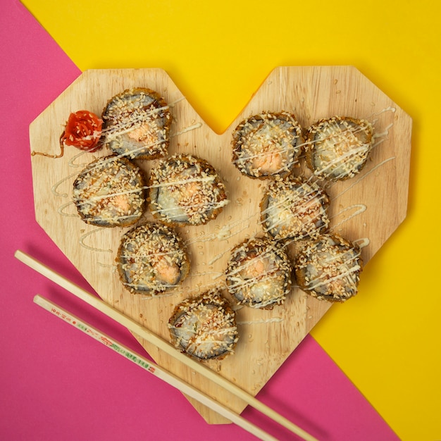 Foto gratuita vista superior de rollos de sushi fritos en forma de corazón con jengibre y wasabi