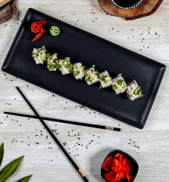 Vista superior de rollos de sushi con hierbas y queso rallado