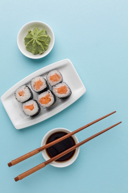Vista superior rollos de sushi con salsa de soja y palillos